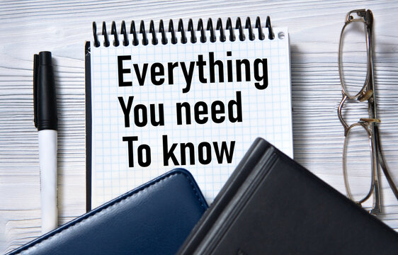 EVERYTHING YOU NEED TO KNOW - words in white paper on the background of a diary, glasses and pen