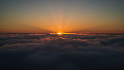 Fototapeta premium 夕暮れの高層雲から射す斜光で太陽光の層を上空俯瞰で描く