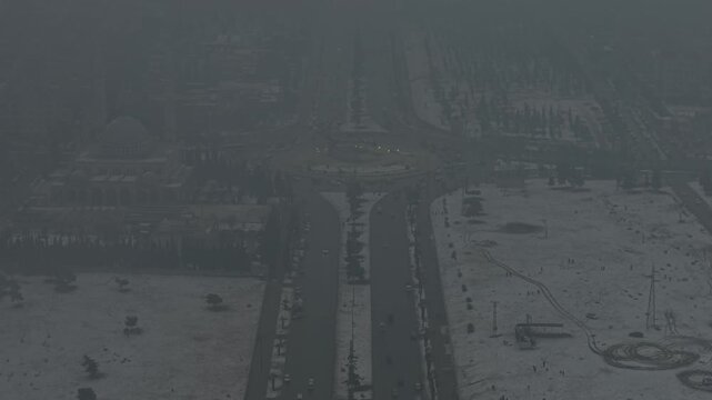 A drone shot of Aleppo, Syria, during a heavy snowstorm shows urban architecture and streets covered in white. Cinematic winter scenery in a Middle Eastern urban environment.