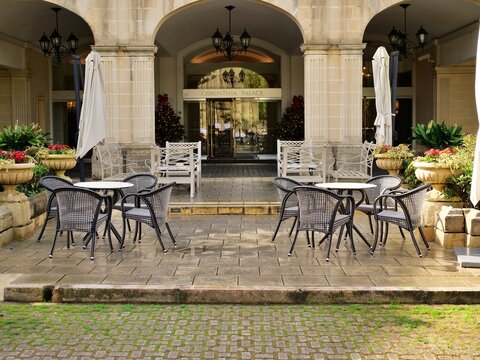 Outdoor cafe seating area at the elegant Corinthia Palace hotel in Malta, featuring
black and white wicker chairs.