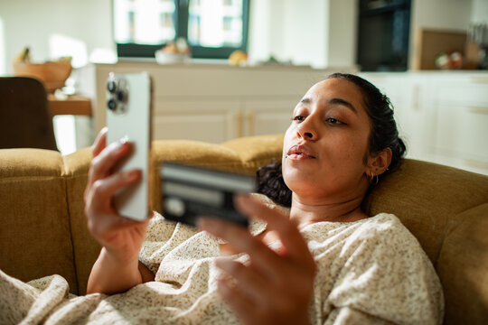 Woman shopping online with credit card on smartphone at home