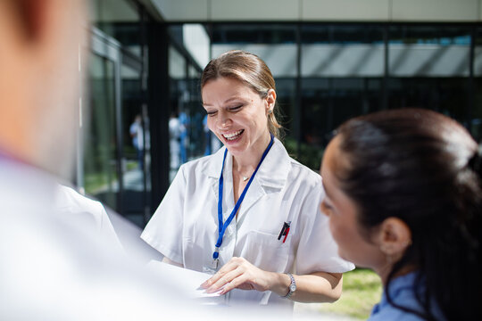 Doctors and nurses having a collaborative meeting outside a hospital