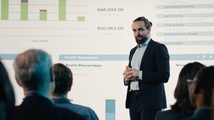 Inspirational business presentation at international summit with diverse mixed age audience, networking event in conference hall. Male CEO presenter speaks to listeners about development.