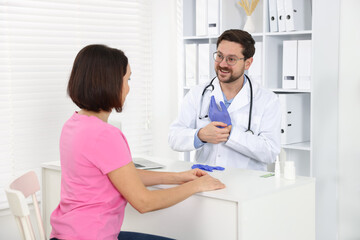Obraz premium Doctor working with patient at white table in clinic