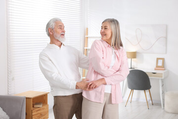 Obraz premium Lovely senior couple dancing together at home