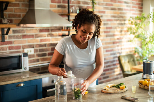 Woman making healthy smoothie in home kitchen