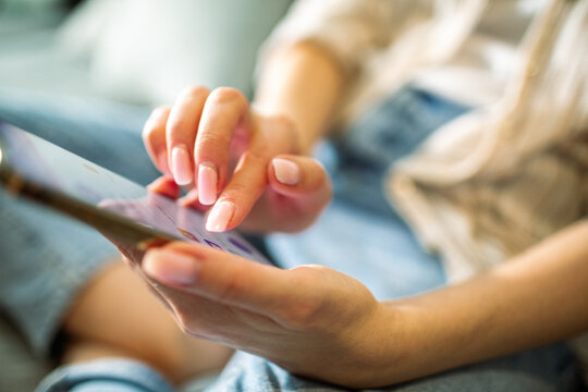 Woman using smartphone at home on couch