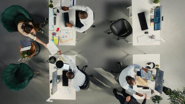 Top down view of business staff in modern office sharing insights and reports, team focuses on data visualization for efficient resource allocation. Company administration. - Powered by Adobe