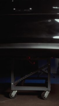 Cinematic close up of an electric vehicle battery pack placed on a rolling service cart inside a modern auto repair shop. High voltage EV technology concept showing professional maintenance diagnostic