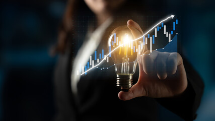 A business professional holds a light bulb symbolizing innovative ideas against a backdrop of data...