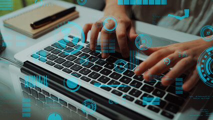 A close-up view of hands typing on a laptop keyboard, enhanced with futuristic data visualizations and graphical interfaces representing technology and innovation. Xenic