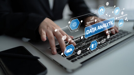 A professional data analyst uses a laptop to explore data analytics, showcasing various icons and infographics to enhance business decision-making and insights. Tessel