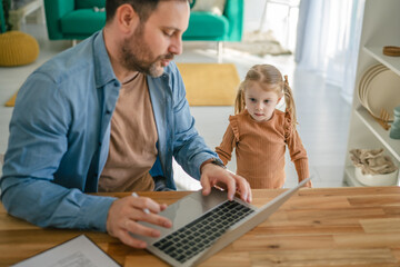 Obraz premium Father multitasking working from home with daughter