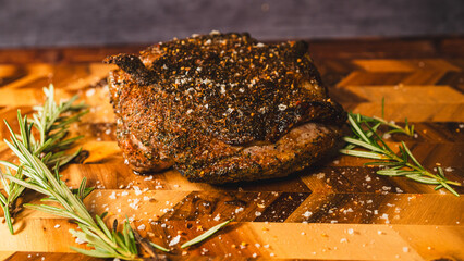 Whole boneless lamb leg roasted with rosemary and spices, crispy outside and juicy inside, presented on a wooden board. Aromatic, tender, perfect for festive carving.