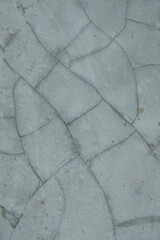 Obraz premium Abstract pattern of cracked concrete pavement with irregular polygonal shapes and dark lines