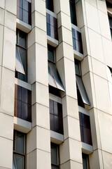 Fototapeta premium Modern building facade with repeating geometric patterns and open windows