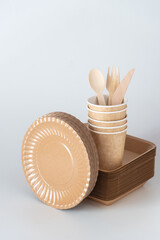 Eco-friendly disposable tableware with paper cups, wooden cutlery, kraft plates, symbolizing sustainable lifestyle, zero waste, and biodegradable packaging.