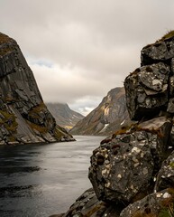 Stunning Rocky Fjord Surrounded By Majestic Mountains Under Dramatic Cloudy Skies