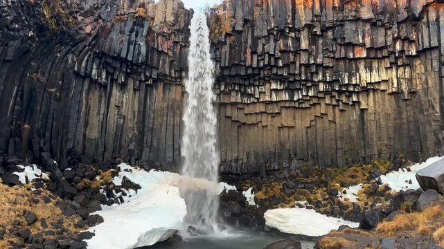 Static Shot of Svartifoss Waterfall with Ice and Basalt Columns, Iceland.