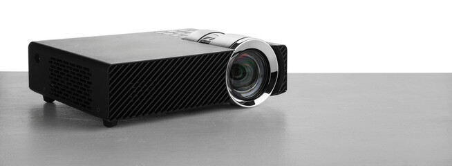 Modern video projector on grey table against white background