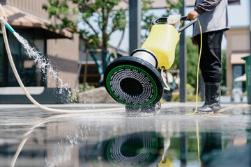 The janitor is cleaning the floor with a floor scrubber.