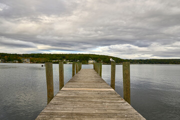 Obraz premium Wooden Pier Leading Across Calm Lake Water in Minimal Landscape