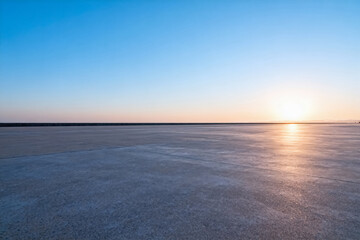 Fototapeta premium Sunset Over Vast Salt Flat with Clear Blue Sky
