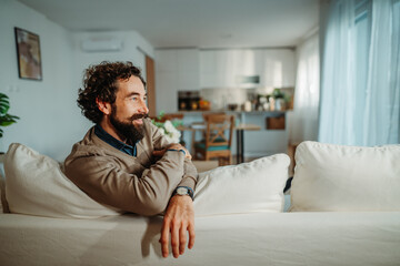 Fototapeta premium Man relaxing on sofa enjoying peaceful home lifestyle