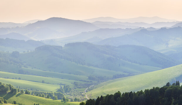 Ridge gradients in haze, view of the summer evening, hills and mountain slopes in sunset light