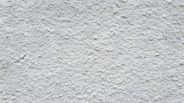 Rough white stucco wall texture with uneven surface and granular appearance.