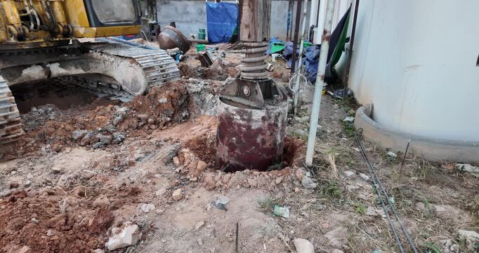 Bored piling drilling bucket and crawler tracks at a construction site.
