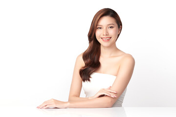 Fototapeta premium A beautiful young Asian woman with clean, fresh skin against a white background. Skincare, facial treatment, cosmetology, beauty, and spa. An elegant portrait of an Asian woman.