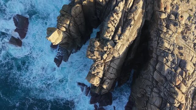 Sea Waves On Cant&iacute;s de Papel Granite Rocks At Sunset Near Xove In Lugo, Galicia, Spain. Aerial Topdown Shot
