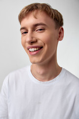 Smiling young man in a white shirt conveys casual happiness and a bright cheerful vibe, perfect for lifestyle, wellness, and positive living visuals