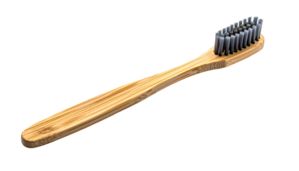 Close-up of a bamboo toothbrush with dark bristles, isolated on a black background