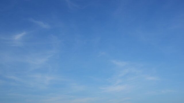 A serene blue sky timelapse video with delicate wispy clouds slowly drifting and reshaping, capturing smooth cloud motion, airy textures, and the tranquil beauty of an open, peaceful daytime sky.
