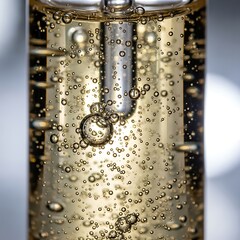 Close-up of Bubbles in a Clear Liquid with a Metal Straw.