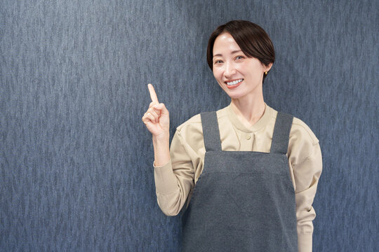 エプロンを着た指差す女性店員