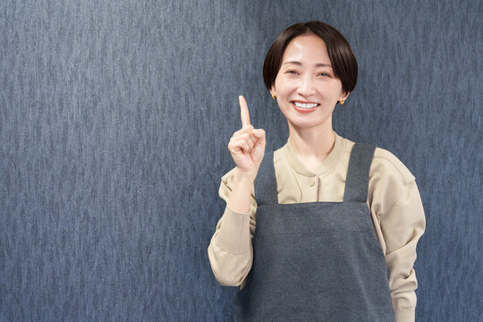 エプロンを着た指差す女性店員