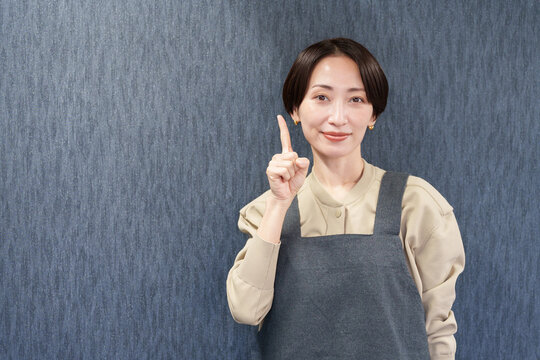 エプロンを着た指差す女性店員