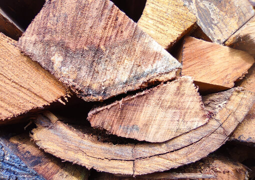 Macro view of split firewood showing exposed grain, fractures, and layered wooden textures in natural brown tones