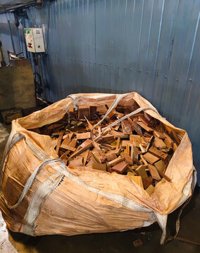 Large industrial sack filled with wooden offcuts inside a manufacturing facility, highlighting raw materials, production remnants, and factory storage systems