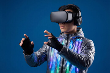 Young man wearing virtual reality headset and futuristic silver jacket with glowing LED lights touching invisible interface. Concept for metaverse, gaming, cyberspace, and immersive digital technology