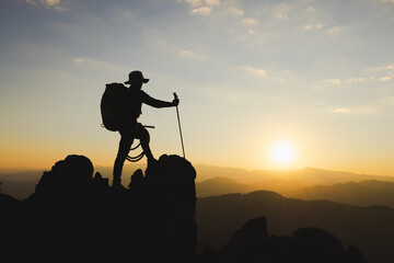 Climber success, silhouette achievements successful arm up man is on top of hill celebrating success with sunrise.