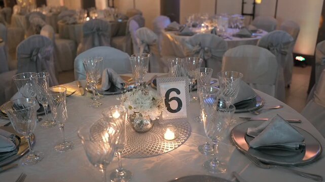 Number six decoration placed on round event table with plates glasses and candles