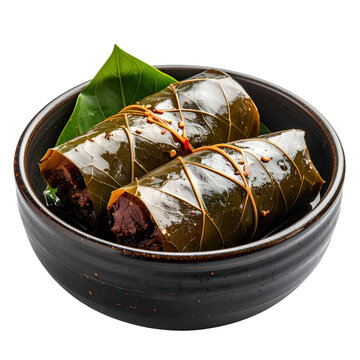 Authentic lu pulu with savory corned beef in taro leaf parcels on a dark plate, isolated on white background for styling.
