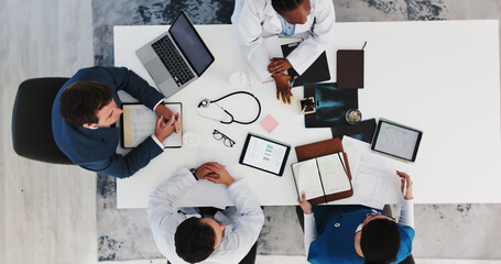 Businessman, doctors and meeting with notes in clinic for surgery funding, action plan or feedback. Paperwork, people and medical team with tech for resource allocation, hospital management and above © SparkPix/peopleimages.com