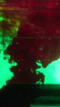 Dropping blood red splatter paint in a water paint
