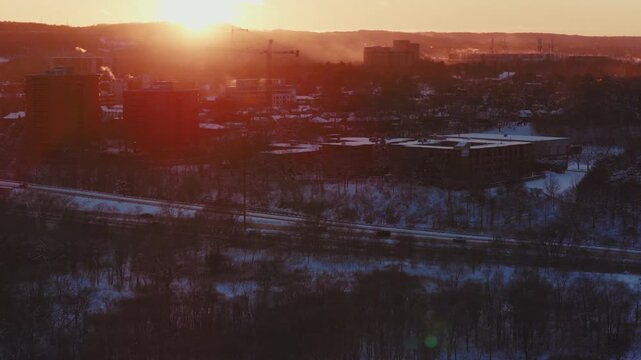 Winter sunset glows over Hamilton, tighter lens gives more parallax effect. The 403 is visible. The vapour and steam billows from the top of buildings.