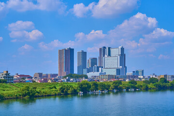 夏の東京都大田区のガス橋から北西側の眺望(川崎市中丸子,下沼部,タワーマンション,多摩川の漁船など)